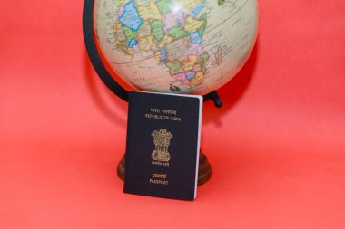 Spark your travel dreams with a classic passport and a world globe resting on a vibrant red background. Ample copy space clipart