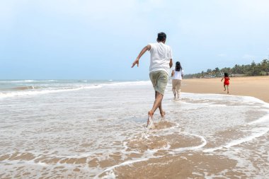 Kaygısız bir aile, güneşin öptüğü kıyı şeridi boyunca hızla ilerler. Kahkahaları, tuzlu meltemi kucaklarken yankılanır. Saf neşe
