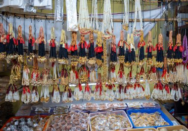 Hareketli bir pazar yerinde titizlikle düzenlenmiş boncuklu kolye, bilezik ve küpeleri keşfedin. İşçiliğin ve mirasın kutlaması..