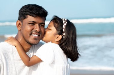 Bir baba ve küçük kızının paylaştığı sakin bir plaj günü. Aşk, kahkaha ve dalgalar.