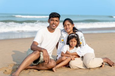 Üç kişilik aile, sahilde güneşli bir günün tadını çıkarır. Birlikte güzel anılar yaratırlar..