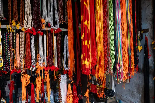 Hareketli bir pazarda, çeşitli ruhsal uygulamaları ve koruyucu tılsımları sembolize eden canlı ritüeller asılı durur..