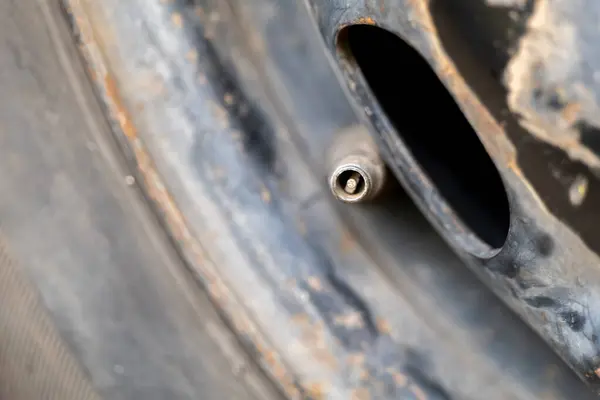 Macro 'nun fotoğrafında tekerlek kenarındaki bir kapakçık sapı görülüyor. Düzenli kontrol ve bakım hava basıncını ve güvenli sürüş koşullarını sağlayın