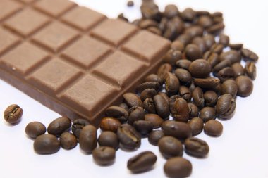 Zengin çikolata ve aromatik kahve çekirdeklerinin birleşimi. Çikolata, dağınık fasulyelerin yanında duruyor, hoşgörü ve enerji uyandırıyor..