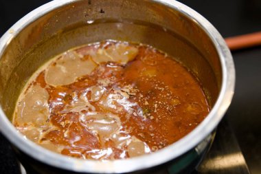 Ocakta paslanmaz çelik bir tencerede kaynayan sıcak bir çorbanın yakın plan çekimi. Mükemmel kış konforlu yemekleri.