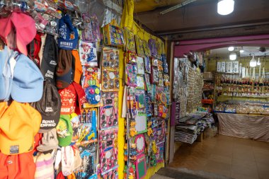 Bu görüntü 17 Mayıs 2024 'te Gokarna City, Karnataka Country India' dan. Hareketli bir Hint pazarındaki hareketli tezgah renkli oyuncaklar, şapkalar, hediyelik eşyalar ve ıvır zıvırlarla dolup taşıyor ve yerel ticarete bir bakış sunuyor.