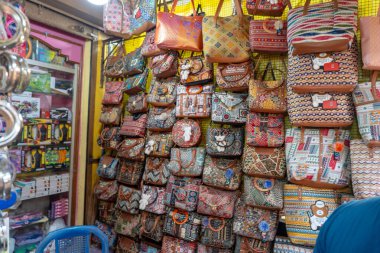Bu görüntü 17 Mayıs 2024 'te Gokarna City, Karnataka Country India' dan. Renkli ve desenli canlı bir duvar patlıyor, çeşitli el yapımı el çantaları sergiliyor.