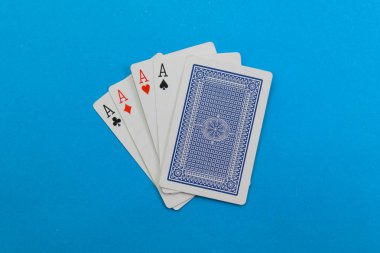 Canlı mavi bir arka planda dört as yayıldı, bir sonraki el için hazır..
