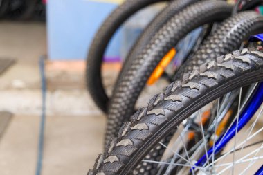 Arka planda diğer motorların bulanıklaştığı yıpranmış bir dağ bisikleti lastiğinin yakın çekimi. Bisiklet, onarım ve macera temaları için mükemmel.