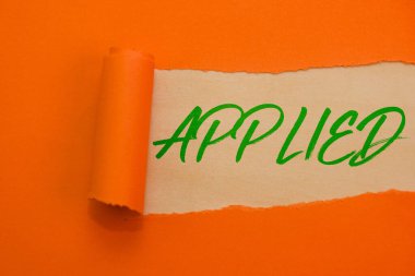 Canlı turuncu yırtık kağıt, başarı ve başarıyı simgeleyen koyu yeşil harflerle 