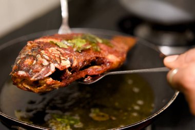 Sulu balık, mükemmel kızartılmış, altın kabuklu, servis edilmeye hazır. Lezzetli bir aşçılık anı.