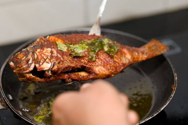 Mükemmel kızarmış balık, baharatlı ve süslü, tavadan servis edilmeye hazır..