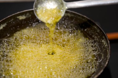 Sıcak Ghee kabarcıkları ve tavada kaynıyor, pişirmeye hazır..