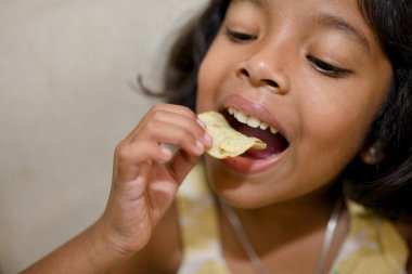 Küçük eller lezzetli bir patates cipsi için uzanır, mükemmel bir atıştırma molası anı..