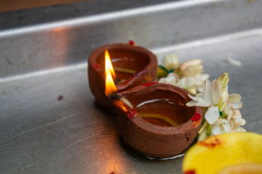 Kil diyas petrolle aydınlatılır, kumkum & yasemin ile süslenir, ışığı, refahı ve yeni başlangıçları simgeler..