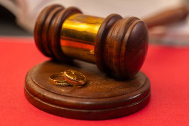 Evlilik yüzükleri yargıcın tokmağının altında duruyor. Boşanma ve yasal ayrılığı simgeliyor..