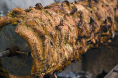 Baharatlı tavuğun dönüşümlü tükürüğü yavaş yavaş pişiyor, traş olmaya hazır lezzetli shawarma.