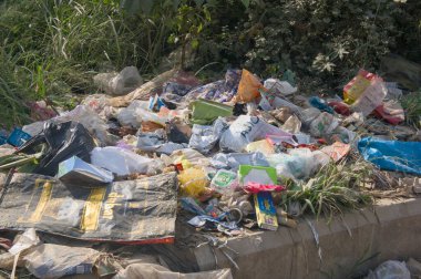 Bu görüntü 20 Aralık 2024 'te Bangalore City, Karnataka Country India' dan. Atılan çöp ve ambalaj çöpleri yol kenarına atılır, çevre kirliliği ve sorumsuz atık imhası vurgulanır.