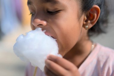 Odak noktası çocuğun yüzü ve kabarık şekerlemeler. Sahne aydınlık ve neşeli..