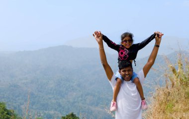 Bu görüntü, kızını omuzlarında taşıyan bir babanın yürek ısıtan bir anını yakalar.