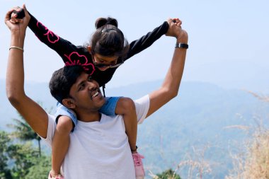 Bir dağın zirvesinde kızını omuzlarında taşıyan bir babanın yürek ısıtan bir sahnesi.