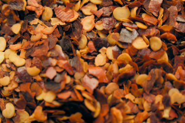 Turuncu, kahverengi ve kırmızı tonlarda çeşitli baharatlar düz bir yüzey üzerinde yakın bir şekilde sıralanır..