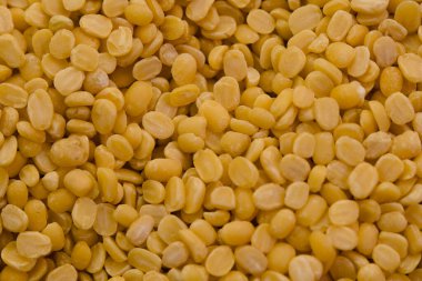 Kurumuş sarı bezelyelerin yakın plan görüntüsü yuvarlak şekillerini ve canlı renklerini vurguluyor, pişirmeye ya da satmaya hazır..