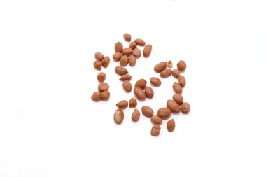 Çeşitli oryantasyonlardaki fıstıklar temiz beyaz arka plana dağılmış, ham dokularını ve renklerini sergiliyorlar..