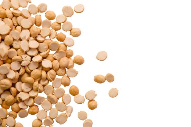 Kurumuş sarı bezelye tohumları beyaz bir yüzeye saçılmış, eşsiz dokularını ve şekillerini sergiliyorlar..