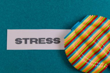 Colorful strips beside stress on a teal surface highlight stress relief activities and materials. clipart