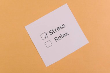 Bir kontrol listesi tamamlanmış olarak işaretlenmiş stresi gösterir ve bir seçenek olarak parlak sarı bir arkaplan karşısında rahatlar.