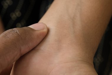 Bir el nazikçe bilek nabzını kontrol eder, kişisel bir anda sağlığa dikkat eder..