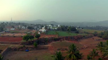 Canlı bir manzarada, bereketli tarlaları çevreleyen palmiye ağaçları berrak mavi gökyüzünün altında verimli tarım arazileri sergiliyor..