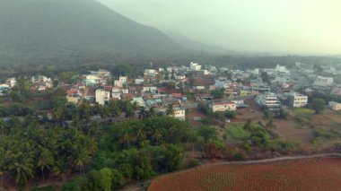Şafak vakti sakin kentsel manzara arka planda dağlar ve yemyeşil alanlar barındırır..