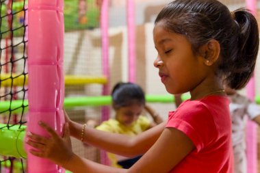 Genç çocuklar canlı bir oyun alanında eğlenceli aktivitelere girişiyor, eğlence ve sosyal etkileşimi teşvik ediyor..