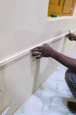 Bir kişi dekoratif süslemeleri titizlikle kurar, ev geliştirme becerilerini ve detaylara olan ilgisini vurgular.