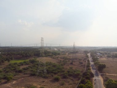 Yeşil arazi üzerindeki hava görüşü, önümüzde uzanan bir yol ve uzak bir köprü..