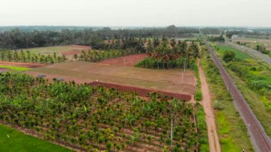 Bereketli tarım arazileri tarım arazileri ve bir yol ile uzanır, demiryolu yakınında huzurlu bir kırsal manzara sağlar..