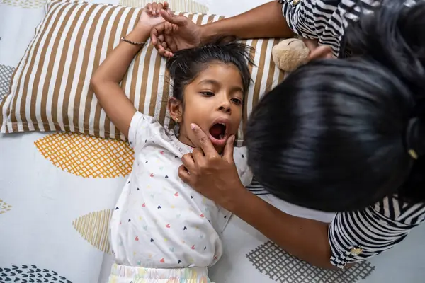 Küçük bir çocuk, ebeveyn gibi esneyerek yatakta uzanıyor ve evde sıcak ve neşeli bir atmosfer yaratıyor..