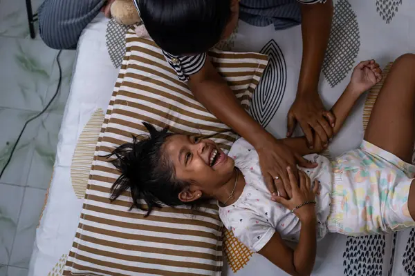 Bir ebeveyn ve çocuk birlikte neşeli bir anı paylaşır, kahkaha ve neşe dolu bir ev ortamında.