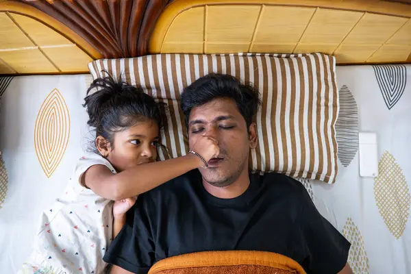 Bir çocuk, babasının evinde huzur içinde yatarken, onu neşeyle dürtüyor..