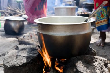 Bir tencere açık ateşin üzerine konur, kırsal bir köyde geleneksel mutfağı hazırlar, yeşilliğin ortasına kurulur..