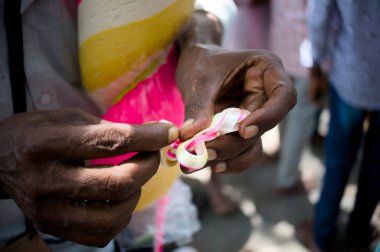 Yetenekli eller, neşe ve gelenekle dolu canlı bir açık hava festivali kutlamasında canlı kurdeleler oluşturuyor..