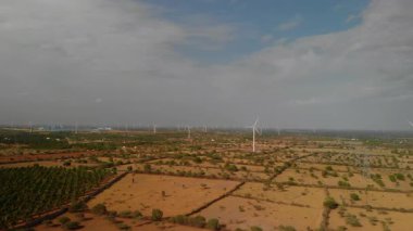 Rüzgâr türbinleri açık gökyüzünde kuru araziye yayılır.