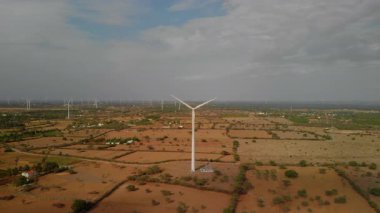 Rüzgâr türbini bulutlu gökyüzünün altında kırsal alanda