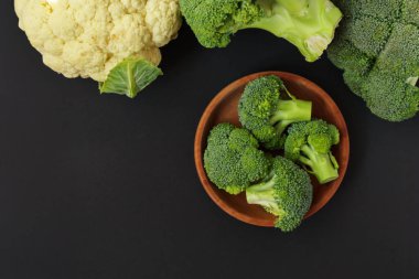 Broccoli and cauliflower on dark background, top view
