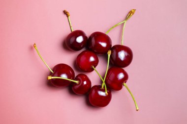 Tatlı sulu kirazlar pembe arka planda.