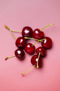 Tatlı sulu kirazlar pembe arka planda.