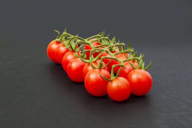 Siyah arka planda taze kiraz domatesleri. Seçici odak.