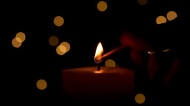 Ateşli kibritle mum yakmak. Mumla Aydınlatan Adam Karanlık Oda ve Noel Işıkları Bokeh 'i Odaklamadı